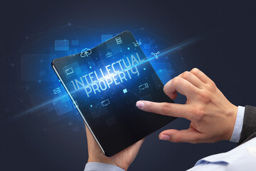 Businessman holding a foldable smartphone, security concept