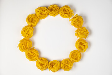 few homemade fettuccine nest in a shape of circle isolated on white background