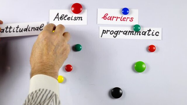 Lecturer giving a presentation about ableism and kinds of barriers for persons with disabilities  using   a white magnetic board. Using of a visual aids. 