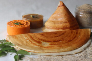 Crispy crepes made of little millets and lentils. Commonly known as little millet dosa. Plated in conical shape and rolls. Served with coconut spicy condiments and sambar.