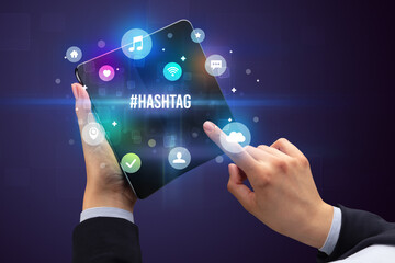 Fototapeta premium Businessman holding a foldable smartphone