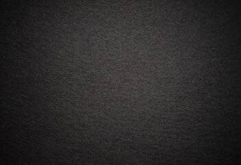 Photo of a black texture made of soft fabric. Dark background of wind. A clean place on a black background for text.