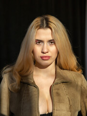 Fototapeta premium Portrait of young woman with blonde hair isolated on black