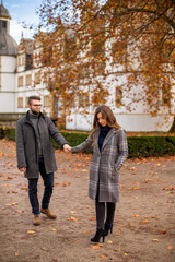 Obraz premium White young european married couple with building behind in autumn