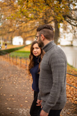 Walking young european married couple in park in fall