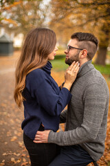 Tender young european married couple in park in fall