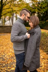 Fototapeta premium Caring tender young european married couple in autumn park