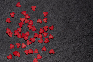 Red sweet hearts are scattered on a black background.Space for text The concept of lovers - 482201020