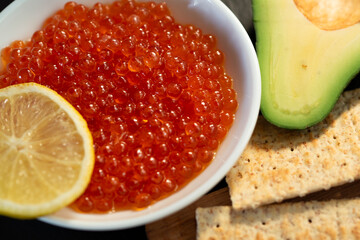 Red caviar, avocado. Close-up. Gourmet food concept - 482201244