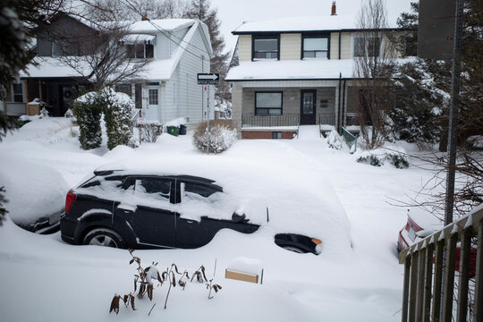Toronto, Ontario / Canada - January 17, 2022 - Toronto St Clair West sideroad with cars covered on day of snowstorm