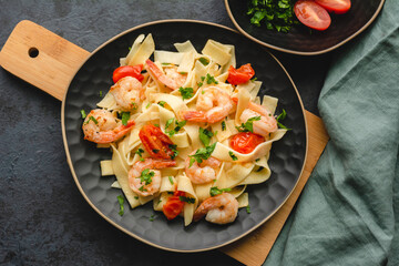 Pasta with shrimp in a garlic sauce with butter, parsley and cherry tomato.