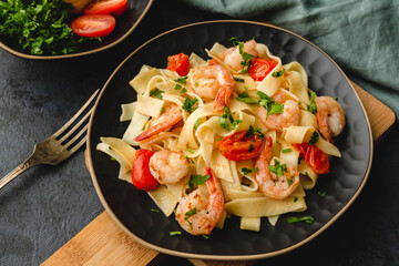 Pasta with shrimp in a garlic sauce with butter, parsley and cherry tomato.