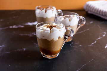 Assortment of mini chocolate and nuts desserts in the glass. Mini choloate desserts on a black background.