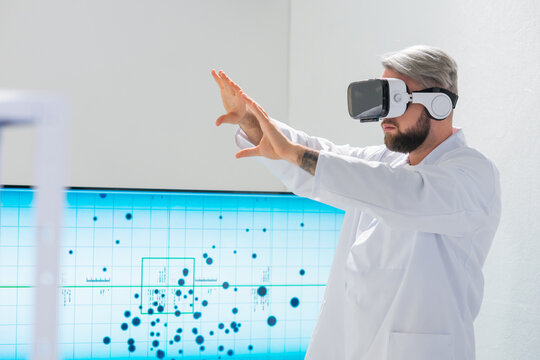 Genetic engineers are using Virtual Reality technology. Professional team of scientists is working on a vaccine in a modern scientific research laboratory. Science of future. - Powered by Adobe