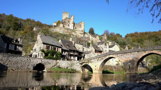 Belcastel, Aveyron, France. 11th of november 2021 : View of the Chateau de Belcastel on a beautiful day with a blue sky with the stone bridge in the foreground