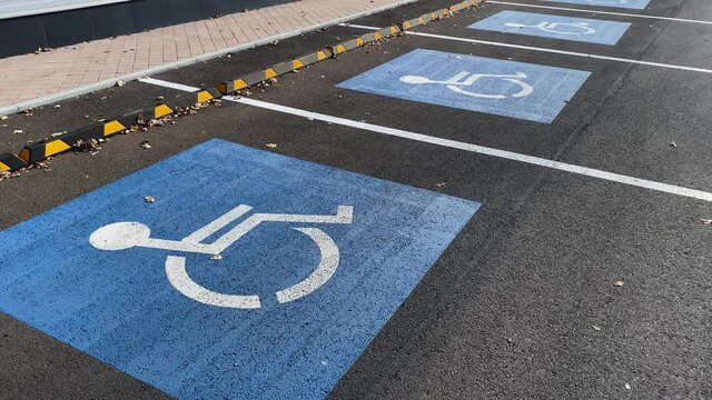 Parking lots for disabled people with painted sign on asphalt.