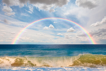 Amazing rainbow over the strong sea wave