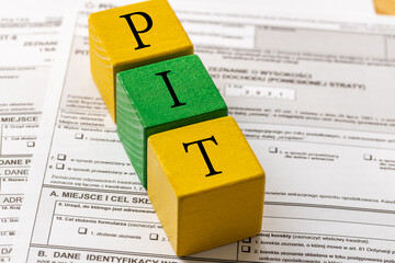 Annual tax settlement in Poland, Form for private persons, Wooden blocks with the word PIT - obrazy, fototapety, plakaty