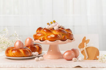 Easter cake, bread, buns, colored eggs, flowers, candies  and bunny,  on the light table with...