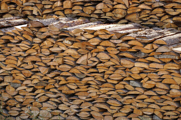 a stack of stacked firewood, harvested lumber, a lot of firewood of various shapes