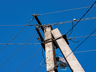 Concrete pole with electric wires against the blue sky. Power transmission line. Energy business....