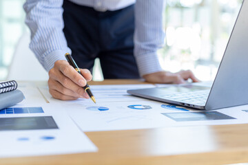 Businessman holding financial documents, he owns a startup company, he sits checking the company's financial summary prepared by the finance department. Management concept of startup company.