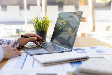 A business men working in a private room, He is typing on a laptop keyboard, He uses a messenger to chat with a partner. Concept of using technology in communication.