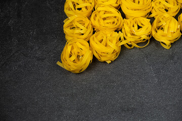 few homemade fettuccine nest isolated on dark background