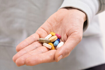 Hand palm with different color pills. medical capsules, supplements or antibiotics, pharmaceutical concept