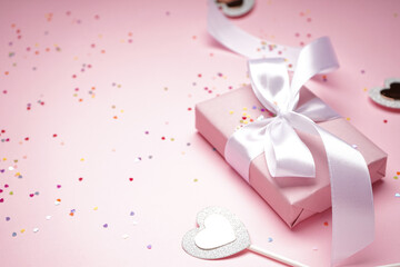 Gift box for Valentine's Day and confetti on pink background, space for text, close up.