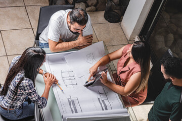 Grupo de personas empresarios analizando planos de construcción de un proyecto