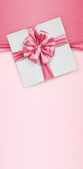 Mothers day gift card, box with pink shiny ribbon bow, isolated on glittering pink background, blank template layout with copy space, top view and also for women's day or greetings card