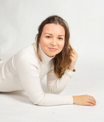 Portrait of smiling attractive young european woman in warm white jumper isolated on white