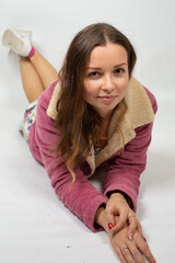 Naklejka premium Portrait of attractive young european woman lying on the floor isolated on light grey