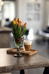 a bouquet of tulips and a cup of coffee are on the table