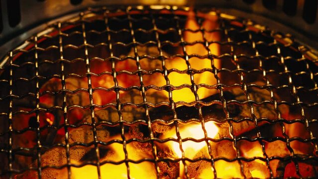 Fire in BBQ Charcoal grill stove for grilling food with smoke hood. It is commonly used in grill restaurants. Found in Asian food such as Korean Japanese and Chinese restaurants. Charcoal stove flames