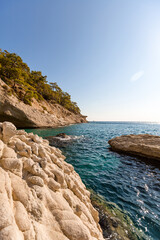 large white stones in azure water against the background of rocks