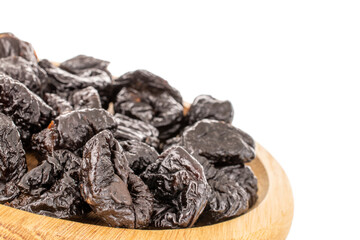 Several organic sweet prunes on a wooden tray, close-up, isolated on white.