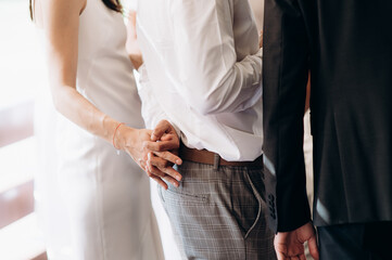 loving couple of newlyweds tenderly hold hands, close-up