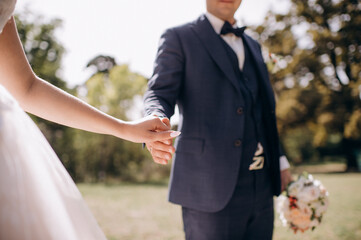 loving couple of newlyweds tenderly hold hands, close-up