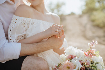 loving couple of newlyweds gently touches with hands, close-up