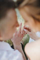 loving couple of newlyweds gently touches with hands, close-up