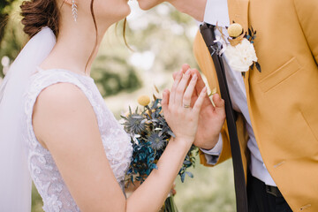 loving couple of newlyweds gently touches with hands, close-up