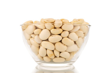 Lots of organic white beans in a glass bowl, macro, isolated on white.