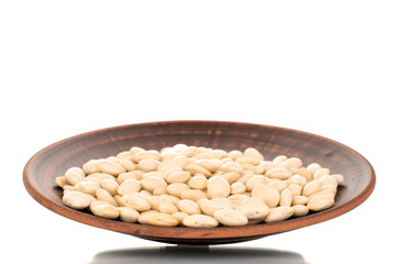 Lots of organic white beans on a clay dish, macro, isolated on white.