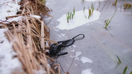 Protective Cloth Face Mask Trapped and Stuck in Ice of Frozen River	

