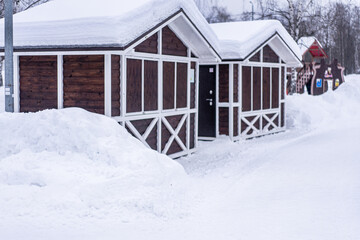 Small wooden closed houses in snowy winter