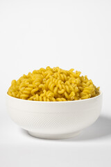 Raw Cavatappi Cellentani pasta in a plate isolated on yellow background