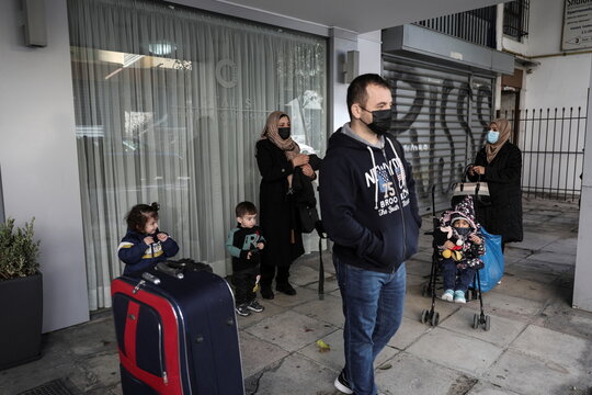 Afghan citizens wait to be transported to the airport from a hotel in central Athens, after being granted visas by Australia, in Athens