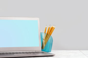 Front view of the laptop with mockup screen on the desk. Copy space. Web banner. Pencils
